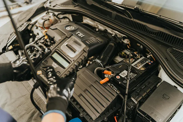 mechanic checking a battery through ampere meter